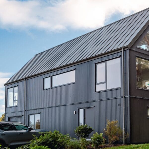 Exterior of modern build house with dark grey cladding and roof