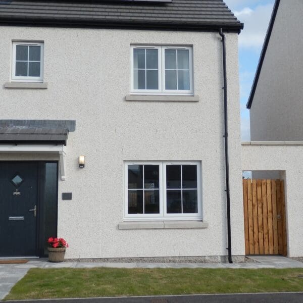 Exterior of house with blue front door and cream harled walls, Glen Brodie self catering, Dornoch
