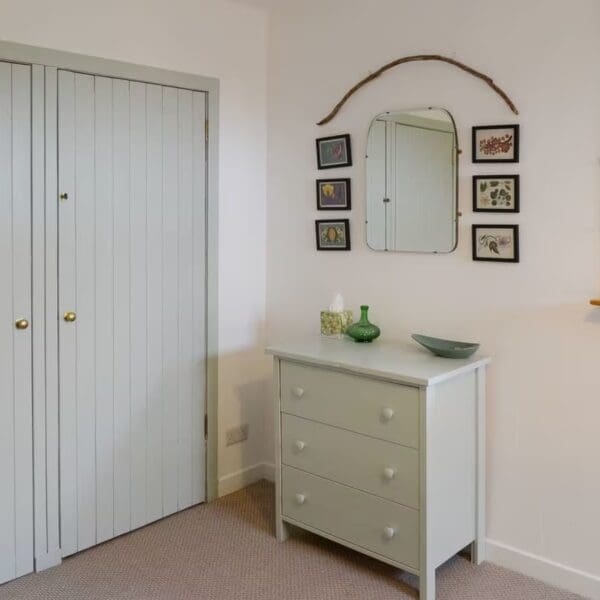 Dressing area with pale blue painted wardrobe doors and matching chest of drawers. Mirror on wall above, Wester Lonemore, Dornoch