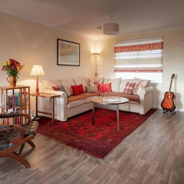 Living room with red rug and cream soft, 67 Grant Crescent Dornoch