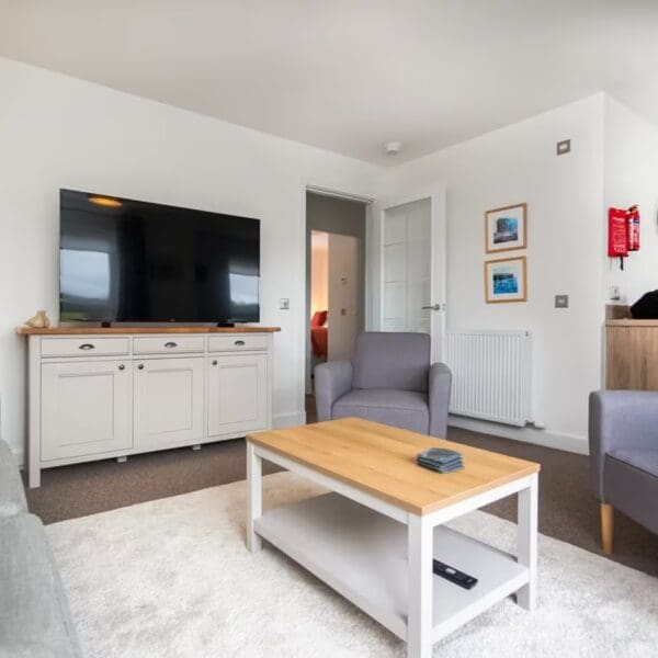 Lounge with large screen tv and grey and purple furnishings, Thistledown holiday apartment, Dornoch