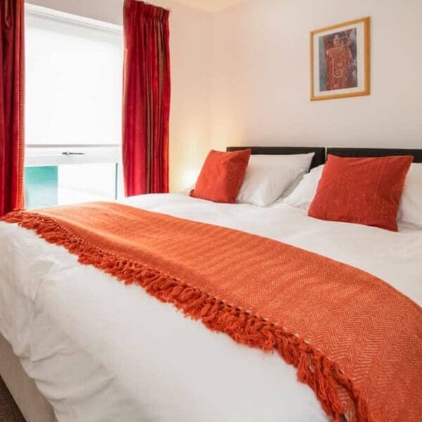 Double bedroom with white and orange decorations, Thistledown Dornoch