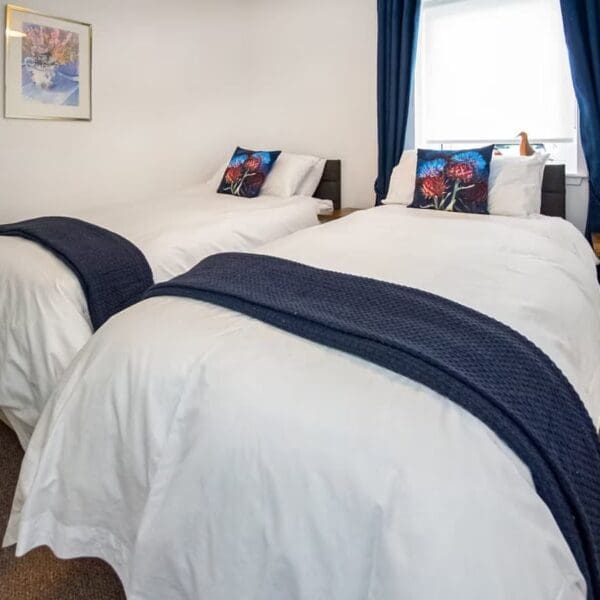 Twin bedroom with white and navy blue furnishings, Thistledown holiday apartment, Dornoch