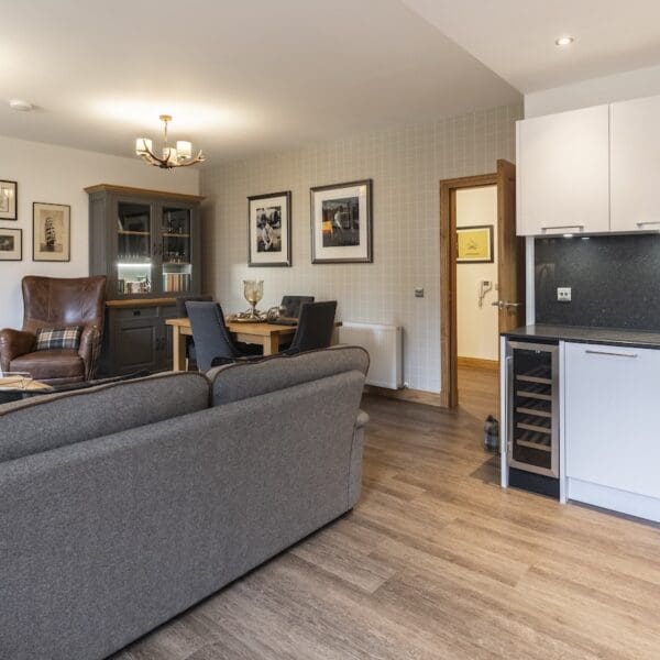 open plan living, dining kitchen area with grey couch 13 Royal Golf Apartments Dornoch