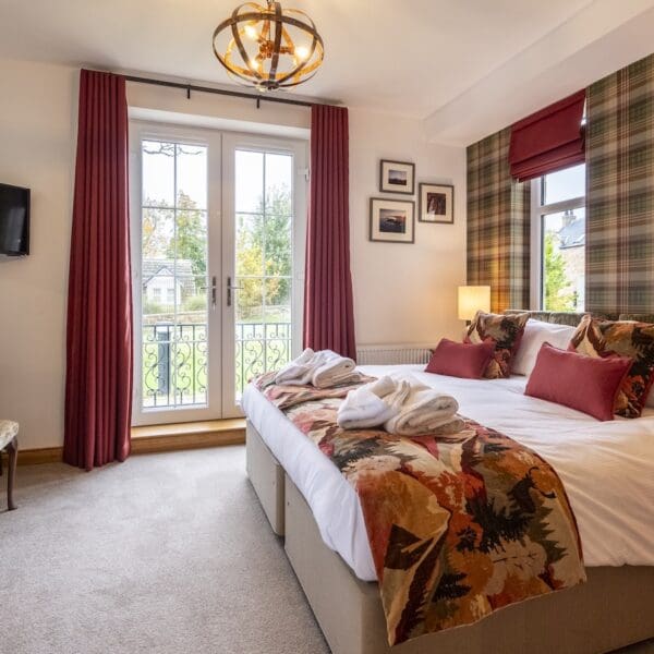 Double bedroom with red tartan decor and patio doors, 13 Royal Golf Apartments Dornoch