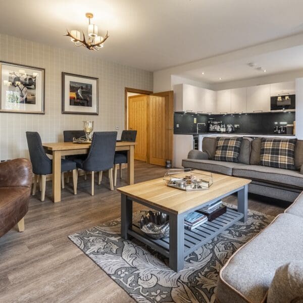 Open plan dining, kitchen, living area with grey suite and pine table, 13 Royal Golf Apartments Dornoch