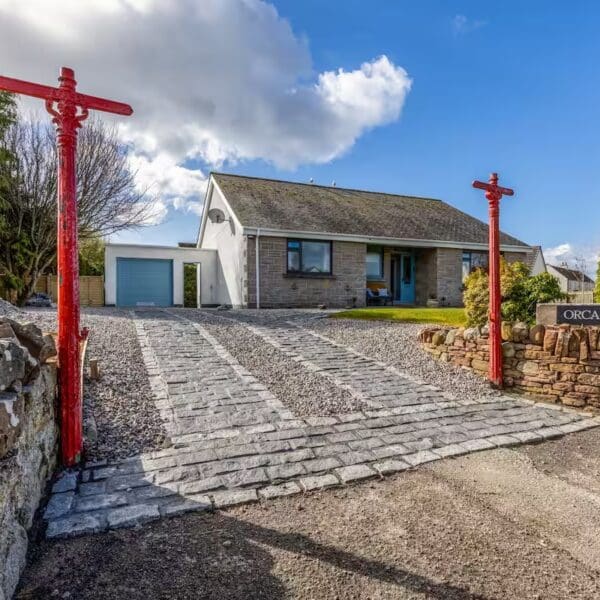 Exterior of Orcadia self catering house, Dornoch with red lamp posts and blue garage door