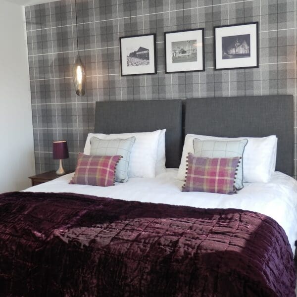 Double bedroom with grey tartan wallpaper and purple bedspread, Glen Brodie self catering, Dornoch