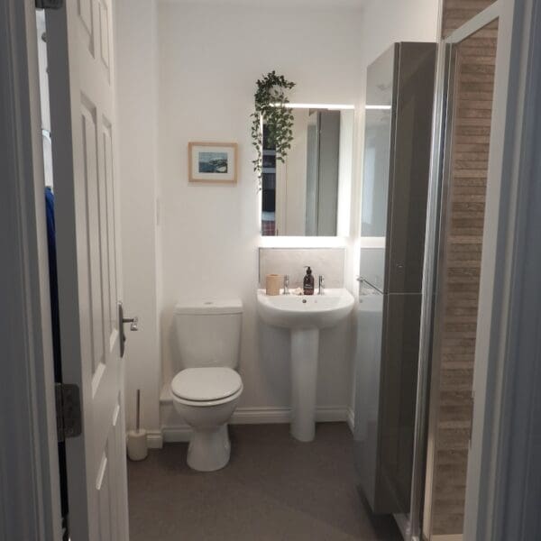 Ensuite shower room with white decor and grey tiled shower, Glen Brodie self catering, Dornoch
