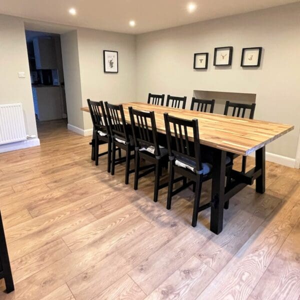 Dining room in Carnegie Cottage, Dornoch with pine table, black chairs and grey decor