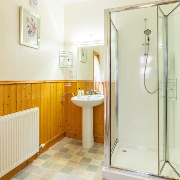Ensuite shower room with white walls and pine panelling, Strathview Lodge B&B Dornoch