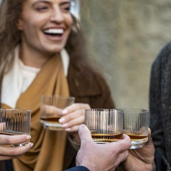 Glenmorangie whisky being held inn tumbler glasses 1600x900