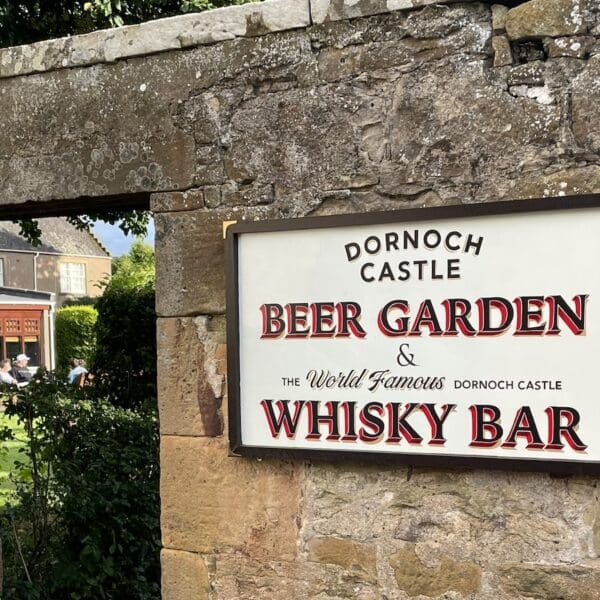 Beer garden sign and view through doorway into walled garden at Castle Hotel, Dornoch Scotland