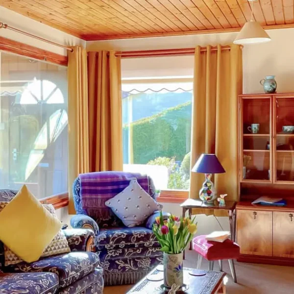 Living room in Achnacarry, Dornoch with pine sideboard and purple suite