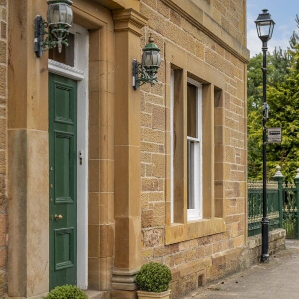 Green door in sandstone building, castle street, dornoch