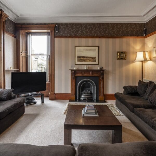 Living room with pine features, brown couches and iron fireplace