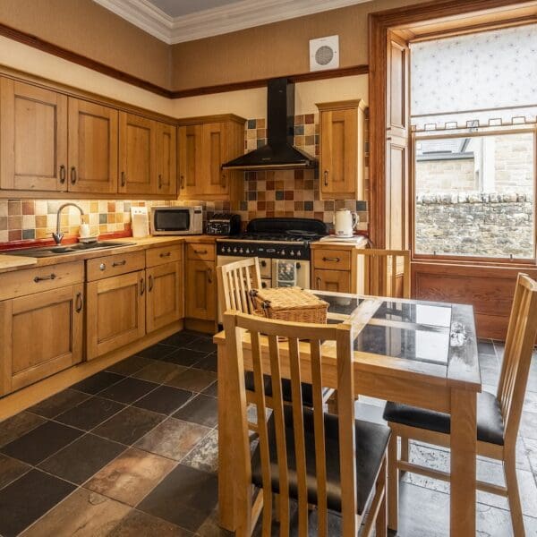 kitchen with pine cabinets, dark tiled floor and pine table and chairs