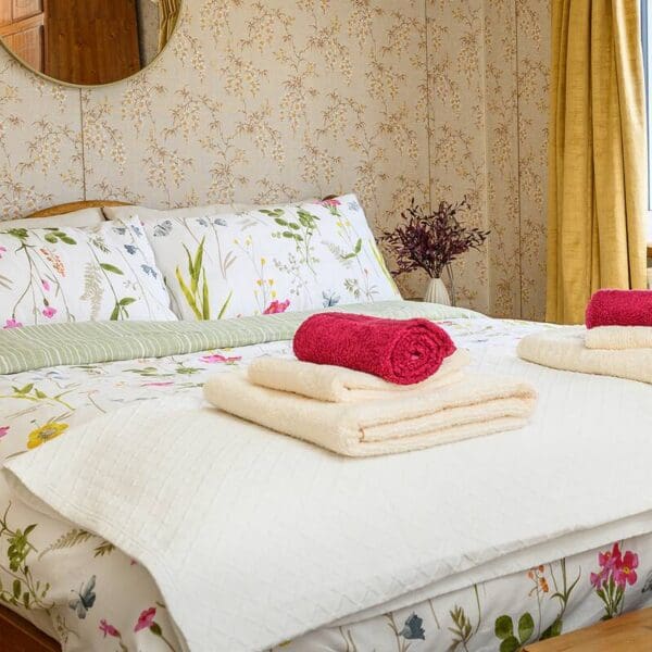 bedroom with pine double bed and floral bedspread