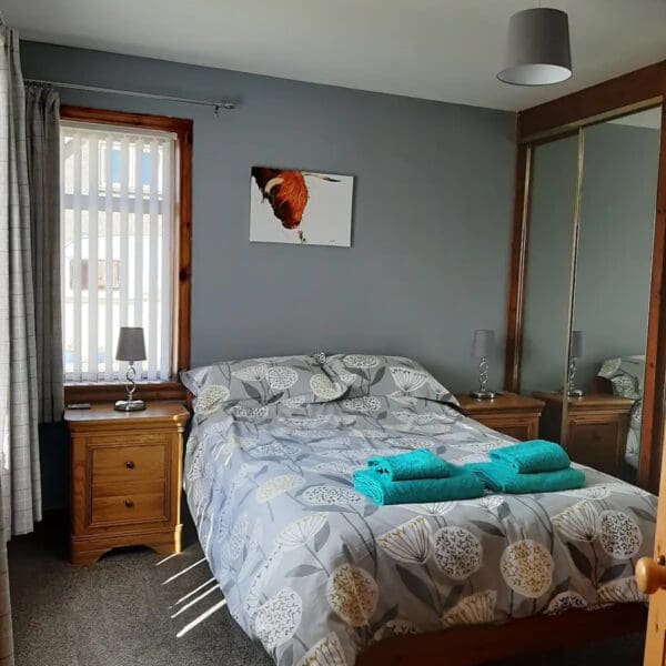 Grey-walled Bedroom with double bed and grey patterned bed spread