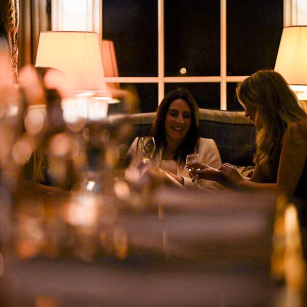 Two women sitting on couch against window of night sky, Anteroom at Links House Hotel Dornoch