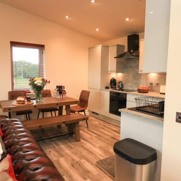 Kitchen dining area in open plan living space. pale grey kitchen cabinets