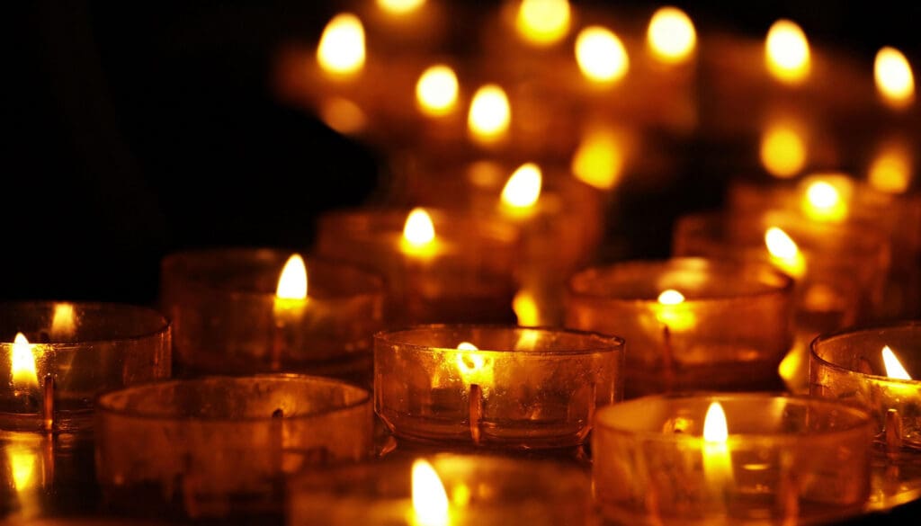 a photo of small lighted candles. The image has an orange and yellow hue.